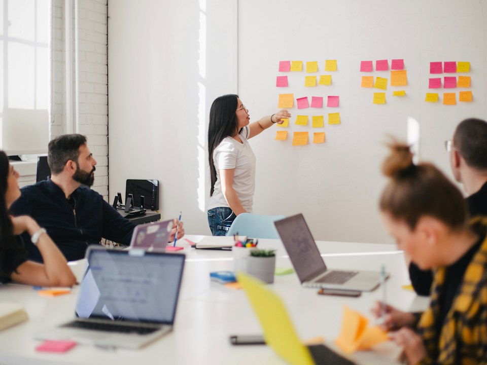 A team mapping a process on a wall of sticky notes
